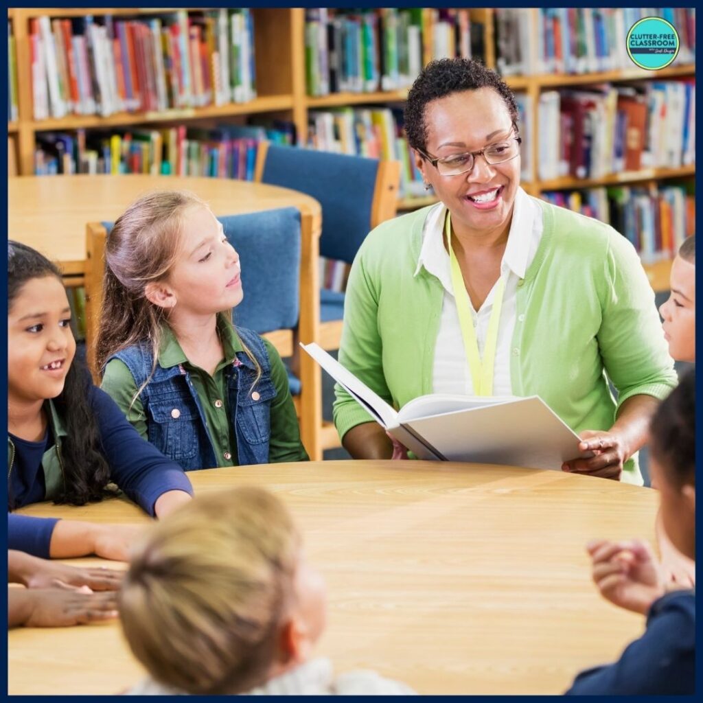 elementary teacher reading aloud a picture book to a small group of students